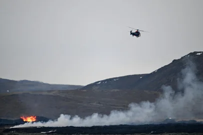 A helicopter of the Icelandic Coast Guard flies over an area with glowing lava near the southwestern Icelandic town of Grindavik after a volcanic eruption on January 15, 2024. Lava flowing from a volcano that erupted on January 14 near the Icelandic fishing port of Grindavik has engulfed at least three homes just hours after villagers were evacuated to safety, authorities said. It was the North Atlantic nation's fifth volcanic eruption in under three years. The most recent occurred just weeks ago on December 18 in the same region, southwest of the capital Reykjavik. (Photo by Halldor KOLBEINS / AFP)Editoria: DISLocal: GrindavikIndexador: HALLDOR KOLBEINSSecao: natureFonte: AFPFotógrafo: STR<!-- NICAID(15650582) -->