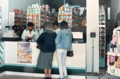 Farmácia de Canguçu nos anos 1980.Uma rede de farmácias ajuda a preservar, no Rio Grande do Sul, uma língua em extinção na Europa. Em quatro lojas das Farmácias Associadas de Canguçu, atendentes falam em pomerano com os clientes. Entre os cerca de 50 mil moradores do município, no Sul do Estado, estão muitos descendentes de imigrantes da Pomerânia, região que hoje pertence à Polônia e à Alemanha.Em 1984, o farmacêutico e empresário Darci Aldrighi abriu a Farmácia Flor do Campo na cidade. Neto de italianos, logo percebeu a dificuldade de comunicação com parte da clientela.<!-- NICAID(16154638) -->