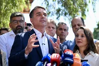 Brazil's right-wing senator and Liberal Party (PL) presidential candidate Flavio Bolsonaro speaks bedide Podemos party president Renata Abreu during a meeting with political party representatives to seek support ahead of the presidential run-off election, in Brasilia on October 8, 2026. (Photo by Evaristo Sa / AFP)<!-- NICAID(16383377) -->