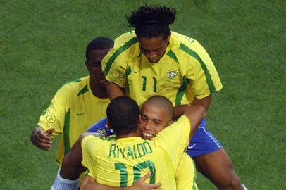 WC2002-MATCH10Brazil's Ronaldo is congratulated by teammates Rivaldo (#10) and Ronaldinho (top#11) after scoring a 50th minute equalizer against Turkey, 03 June 2002 in Ulsan's Munsu Football Stadium, during Group C action between Brazil and Turkey in the 2002 FIFA World Cup.  AFP PHOTO / PASCAL GUYOT (Photo by PASCAL GUYOT / AFP)Editoria: SPOLocal: UlsanIndexador: PASCAL GUYOTSecao: soccerFonte: AFP<!-- NICAID(15131381) -->