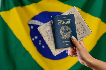 Hand holding Brazilian passport with Brazilian flag in the blurred background.Hand holding Brazilian passport with Brazilian flag in the blurred background.Indexador: Cacio Murilo de VasconcelosFonte: 524097735Fotógrafo: FotÃ³grafo<!-- NICAID(15515999) -->