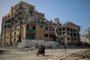 Palestinians drive a motocycle past the destroyed building of the Islamic University in Gaza City on November 26, 2023, on the third day of a truce between Israel and Hamas. Israel faces mounting pressure to extend a four-day pause in its war against Hamas, but military officials fear that a longer truce risks blunting its efforts to rout the Islamist movement. (Photo by Omar El-Qattaa / AFP)<!-- NICAID(15609606) -->