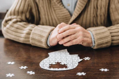 cropped view of senior man playing with puzzles on tableFonte: 241431741<!-- NICAID(15501614) -->