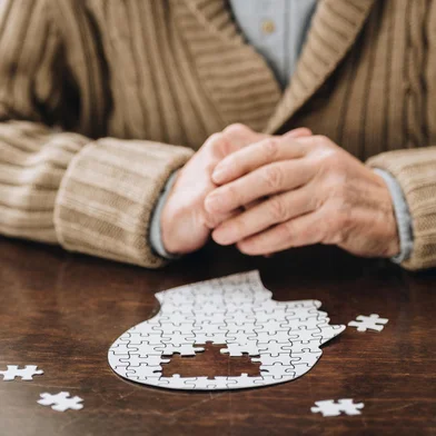 cropped view of senior man playing with puzzles on tableFonte: 241431741<!-- NICAID(15501614) -->