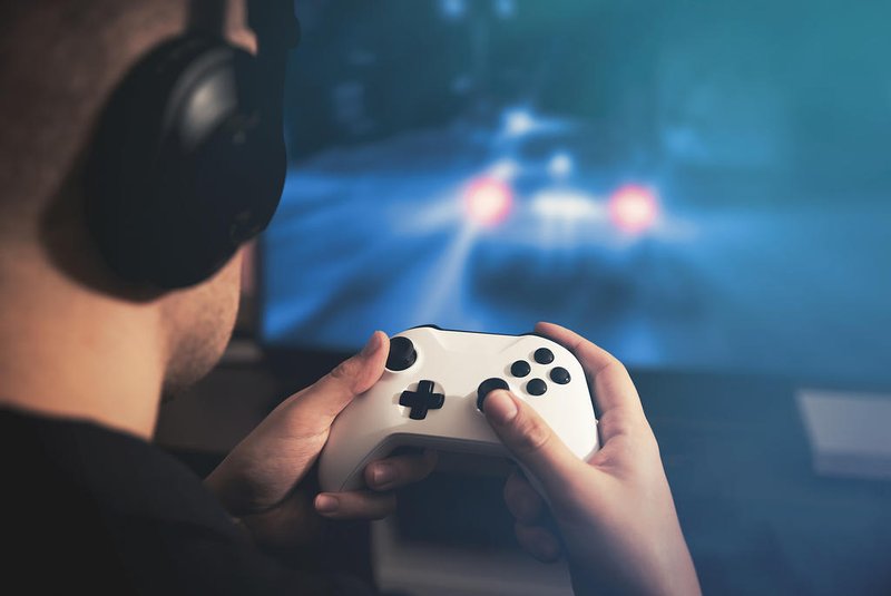Man holding game pad and playing car race gameControle de video game, xbox,  televisão. Foto: Proxima Studio / stock.adobe.comFonte: 251818119<!-- NICAID(15112015) -->