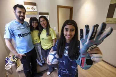Bruno Todeschini / Grupo RBS PORTO ALEGRE, RS, BRASIL, 09-10-2026: A família de Daniela Souza e Igor Braz vive a expectativa para o jogo da Seleção Feminina em Porto Alegre. Será a primeira vez que eles irão ao estádio juntos. A filha mais velha, Melissa Braz, é fã da seleção e também joga na escolinha do Grêmio. A irmã mais nova, Maria Clara Braz, também vai acompanhar a partida com a família. Foto: Bruno Todeschini/Grupo RBS<!-- NICAID(16384521) -->