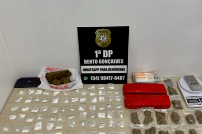Na tarde desta quinta-feira (24), a Polícia Civil, por meio da 1ª Delegacia de Polícia de Bento Gonçalves, deflagrou uma ação policial voltada à repressão ao tráfico de drogas no município. A ação foi resultado de uma investigação conduzida pela equipe da Seção de Investigações, cujos alvos eram mãe e filha, que estariam armazenando, em uma residência no bairro Zatt, drogas para esquema de tele-entrega. Por volta das 14 horas, a mãe, de 48 anos, e a filha, de 23, foram presas em flagrante em poder de 99 porções de cocaína, 02 tijolos de maconha, uma sacola com pedaços de maconha, 25 porções de maconha, 02 balanças de precisão e centenas de embalagens do tipo ziplock, para acondicionamento da droga.<!-- NICAID(16087474) -->