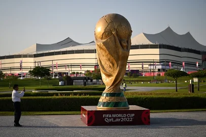 FBL-WC-2022-STADIUM-AL-BAYTA man takes a picture of a FIFA World Cup trophy replica in front of the Al-Bayt Stadium in al-Khor on November 10, 2022, ahead of the Qatar 2022 FIFA World Cup football tournament. Taça da Copa do MundoKirill KUDRYAVTSEV / AFP