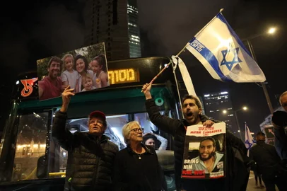 An Israeli man waves a national flag and shouts slogans as another protester holds up a photo of the Kedem Siman Tov family -- who were killed in Nir Oz during the October 7 Hamas attack on southern Israel -- at a protest in Tel Aviv on March 2, 2024, held amid the continuing conflict in the Gaza Strip between Israel and the Palestinian militant Hamas movement. (Photo by JACK GUEZ / AFP)<!-- NICAID(15696442) -->