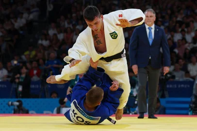 Brazil's Daniel Cargnin and Kosovo's Akil Gjakova (Blue) compete in the judo men's -73kg round of 32 round bout of the Paris 2024 Olympic Games at the Champ-de-Mars Arena, in Paris on July 29, 2024. (Photo by Jack GUEZ / AFP)<!-- NICAID(15825396) -->