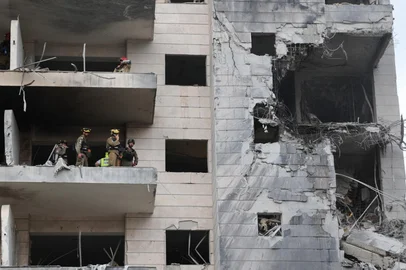 Responders inspect a damaged building following a strike by an Iranian missile in the Israeli city of Petah Tikva, east of Tel Aviv, on June 16, 2025. Israel's military warned on June 16 of a new missile salvo incoming from Iran, as AFP journalists reported loud explosions in Jerusalem and fires outside the coastal city of Haifa. "A short while ago, the IDF identified missiles launched from Iran toward the territory of the State of Israel," the army posted on Telegram, using the acronym for its official name. (Photo by Jack GUEZ / AFP)<!-- NICAID(16060354) -->