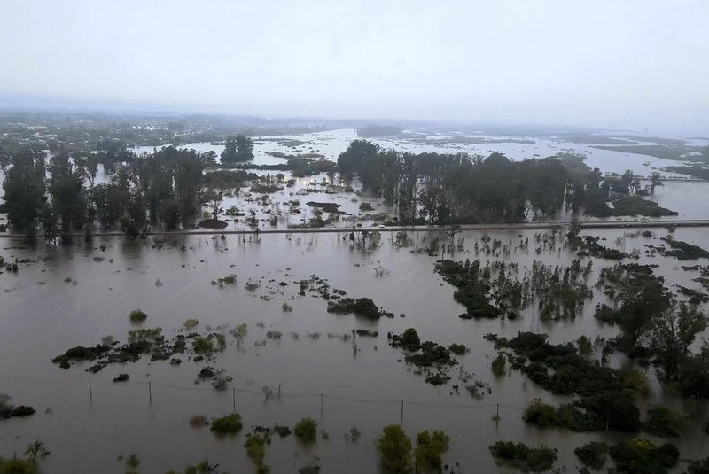 This grab picture taken from a handout video released by the Treinta y Tres Mayor's Office shows an aerial view the over-flooded Olimar River in Treinta y Tres, in the Uruguayan eastern department of the same name, on May 8, 2024. More than 1300 people have been displaced from their homes in Uruguay according to the last report by Uruguay's crisis management National Emergency System (Sinae) agency on May 8. The floodings, mostly in departments bordering Brazil, were triggered by very heavy storms and rainfall in the last couple of days. (Photo by Treinta y Tres Mayor's Office / AFP) / RESTRICTED TO EDITORIAL USE - MANDATORY CREDIT "AFP PHOTO / TREINTA Y TRES MAYOR'S OFFICE" - NO MARKETING NO ADVERTISING CAMPAIGNS - DISTRIBUTED AS A SERVICE TO CLIENTSEditoria: WEALocal: Treinta y TresIndexador: -Secao: meteorological disasterFonte: Treinta y Tres Mayor's OfficeFotógrafo: Handout<!-- NICAID(15762451) -->