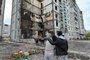People pay their respects as flowers are laid in front of a damaged multistory residential building, where a Russian strike killed 23 people, in Uman, Cherkasy region, on April 30, 2023. - A Russian strike on a block of flats in the central Ukrainian city of Uman killed 23 people, including a baby boy on April 28, 2023. (Photo by Genya SAVILOV / AFP)Editoria: WARLocal: UmanIndexador: GENYA SAVILOVSecao: warFonte: AFPFotógrafo: STF<!-- NICAID(15417164) -->