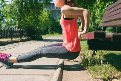 Woman in sportswear doing exercise on triceps on a park benchFonte: 120480868<!-- NICAID(15525118) -->
