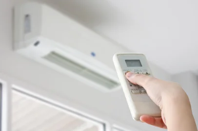 Hand with remote control directed on air conditionerFonte: 105990724<!-- NICAID(14997285) -->