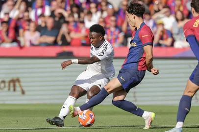 Real Madrid's Brazilian forward #07 Vinicius Junior fights for the ball with Barcelona's Spanish defender #32 Hector Fort during the Spanish league football match between FC Barcelona and Real Madrid CF at Estadi Olimpic Lluis Companys in Barcelona, on May 11, 2025. (Photo by LLUIS GENE / AFP)<!-- NICAID(16035261) -->
