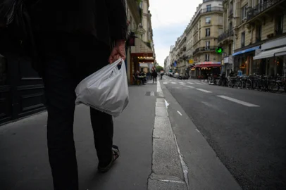 A shopper carries a plastic bag on a street in Paris on September 11, 2024. (Photo by Ed JONES / AFP)Editoria: ENVLocal: ParisIndexador: ED JONESSecao: environmental politicsFonte: AFPFotógrafo: STF<!-- NICAID(15867488) -->