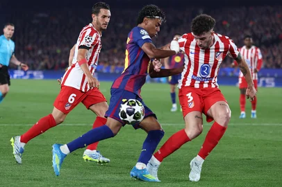 Barcelona's Spanish forward #10 Lamine Yamal fights for the ball with Atletico Madrid's Spanish midfielder #06 Koke and Atletico Madrid's Italian defender #03 Matteo Ruggeri during the UEFA Champions League quarter final first leg football match between FC Barcelona and Club Atletico de Madrid at Camp Nou Stadium in Barcelona on April 8, 2026. (Photo by Josep LAGO / AFP)<!-- NICAID(16263006) -->
