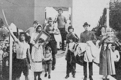 Além de pautar a Festa da Uva de 1975, o centenário da imigração italiana também rendeu uma badalada solenidade em Nova Milano, o chamado berço da colonização.. Foi em 20 de maio de 1975, quando o presidente Ernesto Geisel retornou a Serra para uma intensa agenda em Farroupilha e Caxias.Na foto: representação simbólica da chegada dos primeiros imigrantes, com a participação de moradores locais, do corpo de baile da Escola de Balé Dora Rezende Fabião e do CTG Rincão da Lealdade.Detalhe: o professor, pesquisador e estudioso da imigração Ary Trentin participou da encenação trajado como um imigrante vêneto (na foto acima, à direita).<!-- NICAID(16012765) -->