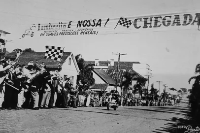 Ídolo do ciclismo caxiense nos anos 1950 e 1960, Charles Lamb também se consagrou sobre motonetas. Foi ele o grande vencedor da “Grande Prova de Motonetas da ZYF-3”, competição promovida pela Rádio Caxias por ocasião de seu 14º aniversário.A corrida ocorreu em 24 de abril de 1960, mobilizando 15 pilotos de Lambrettas e Vespas. Legenda: momento da chegada de Charles Lamb à Rua Pinheiro Machado, entre a Marechal Floriano e a Moreira César (ao fundo) - na época, todas as vias centrais eram de mão dupla. <!-- NICAID(16335520) -->