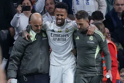 Real Madrid's Brazilian defender #03 Eder Militao walks off with assistance after sustaining an injury during the Spanish league football match between Real Madrid CF and RC Celta de Vigo at the Santiago Bernabeu Stadium in Madrid on December 7, 2025. (Photo by Thomas COEX / AFP)<!-- NICAID(16182624) -->