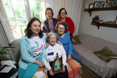 NOVA PRATA, RS, BRASIL, 13/11/2024. Moradoras de Nova Prata, devotas da Mãe e Rainha Três Vezes Admirável de Schoenstatt, lançam imagem da santa em balões para propagar a fé. A reportagem conversou conversou com as devotas para entender como teve início essa tradição. Na foto, Clóris Aparecida Lenzi da Fonseca (de azul), Rosângela Lazzari, 69 anos (de verde), Nadia Colao Merlo, 72 anos (de vermelho), Ana Clara Lazzari Lorenzini, 73 anos (de roxo) e Neri Lenzi, 96 anos (com a santa). (Bruno Todeschini/Agência RBS)Indexador: Bruno Todeschini<!-- NICAID(15913663) -->
