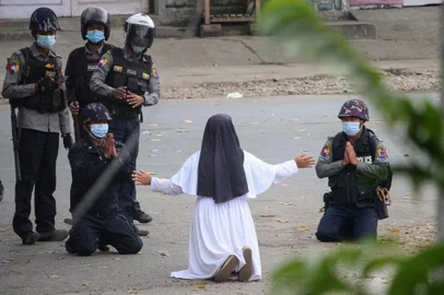 This handout photo taken on March 8, 2021 and released on March 9 by the Myitkyina News Journal shows a nun pleading with police not to harm protesters in Myitkyina in Myanmar's Kachin state, amid a crackdown on demonstrations against the military coup. (Photo by Handout / Myitkyina News Journal / AFP) / RESTRICTED TO EDITORIAL USE - MANDATORY CREDIT "AFP PHOTO / Myitkyina News Journal " - NO MARKETING - NO ADVERTISING CAMPAIGNS - DISTRIBUTED AS A SERVICE TO CLIENTS<!-- NICAID(14731709) -->