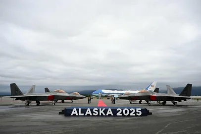 F-22 fighter jets are seen on the tarmac with Air Force One in the distance after US President Donald Trump landed at Joint Base Elmendorf-Richardson in Anchorage, Alaska, on August 15, 2025. US President Donald Trump touched down at the military base in Alaska for a much-anticipated summit with Russian counterpart Vladimir Putin to press for an end to Moscow's bloody war in Ukraine. (Photo by ANDREW CABALLERO-REYNOLDS / AFP)<!-- NICAID(16102715) -->