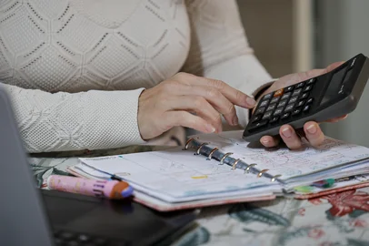 CANOAS, RS, BRASIL, 13-07-2026: Ana Paula Lopes com anotações em agenda e planilhas de gastos no computador, em casa, em Canoas. Ela precisou resgatar dinheiro de aplicações para pagar dívidas e quitar financiamento. Foto: Mateus Bruxel/Agência RBSIndexador: MATEUS BRUXEL<!-- NICAID(16326166) -->