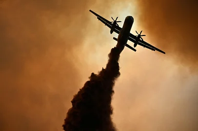 This photograph shows a dash 8 of the French civil security droping fire retardant over a wildfire near Fontjoncouse, southwestern France, on August 6, 2025. A wildfire has killed one person and injured nine others, scorching 11,000 hectares as firefighters work to contain the blaze, local officials said. The fire, which started the day before, has destroyed or damaged 25 homes in the southern Aude department, where more than 1,800 firefighters have been battling to control what is now the largest wildfire in France this summer. (Photo by Lionel BONAVENTURE / AFP)Editoria: DISLocal: FontjoncouseIndexador: LIONEL BONAVENTURESecao: natural resourcesFonte: AFPFotógrafo: STF<!-- NICAID(16097683) -->