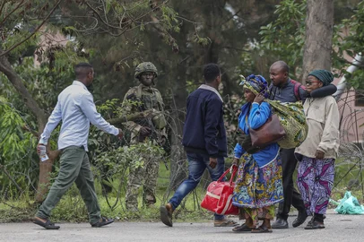 A member of the M23 armed group holds position behind barbed wire as civilians fleeing ongoing clashes in eastern Democratic Republic of Congo cross the border into Rwanda at the La Corniche Border Post in Gisenyi on January 29, 2025. The fate of DR Congo's besieged city of Goma appeared to be all but sealed on January 29, 2025, after Rwandan-backed fighters seized control of the airport and most of the centre and neighbourhoods of the key mineral trading hub. (Photo by Tony KARUMBA / AFP)<!-- NICAID(15963817) -->