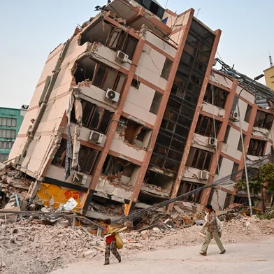 Children walk past a collapsed building in Mandalay on April 2, 2025, five days after a major earthquake struck central Myanmar. Days after a shallow 7.7-magnitude earthquake that killed more than 2,000 people, many people in Myanmar are still sleeping outdoors, either unable to return to ruined homes or afraid of further aftershocks. (Photo by AFP)<!-- NICAID(16008552) -->