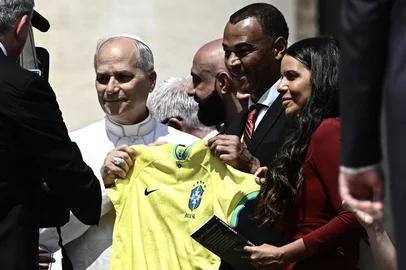 Former Brazilian footballer Cafu (2R) and Pope Leo XIV (L) poses for a photo holding a Brazil national football team jersey during the weekly general audience in St Peter's Square at the Vatican on June 11, 2025. (Photo by Filippo MONTEFORTE / AFP)<!-- NICAID(16057417) -->