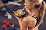 Top view of woman eating healthy food while sitting in a gym. Healthy lifestyle concept.Indexador: Milan IlicFonte: 239975148<!-- NICAID(15486571) -->