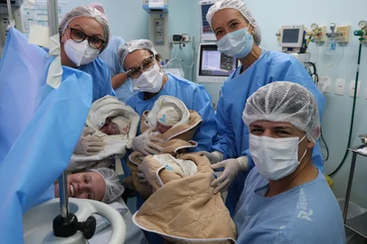 Pais de trigêmeos e equipe médica