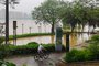 Um ciclista pedala pelas enchentes perto de um rio na cidade de Qingyuan, na província de Guangdong, no sul da China, em 21 de abril de 2024. Deslizamentos de terra no sul da China feriram pelo menos seis pessoas e prenderam outras, informou a mídia estatal em 21 de abril, enquanto a região se preparava para inundações graves "observadas cerca de uma vez por século"<!-- NICAID(15741171) -->