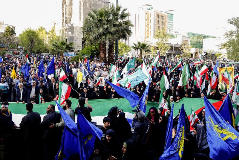 Iranians wave flags during a celebration following Iran's missiles and drones attack on Israel, on April 15 2024, at Palestine square in central Tehran. Iran launched the attack on April 14, its first ever to directly target Israeli territory, in retaliation for a deadly air strike widely blamed on Israel that destroyed Tehran's consular building in Syria's capital early this month. (Photo by ATTA KENARE / AFP)<!-- NICAID(15735914) -->