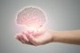Man holding brain illustration against gray wall background. Concept with mental health protection and care.Fonte: 321477841<!-- NICAID(15655034) -->