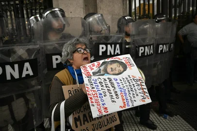 A woman shouts slogans in front of the police during a protest of pensioners supported by football fans against the government of President Javier Milei in Buenos Aires on March 12, 2025. (Photo by Luis ROBAYO / AFP)Editoria: WARLocal: Buenos AiresIndexador: LUIS ROBAYOSecao: demonstrationFonte: AFPFotógrafo: STF<!-- NICAID(15994816) -->