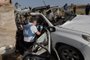 EDITORS NOTE: Graphic content / United Nations staff members inspect the carcass of a car used by US-based aid group World Central Kitchen, that was hit by an Israeli strike the previous day in Deir al-Balah in the central Gaza Strip on April 2, 2024, amid the ongoing battles between Israel and the Palestinian militant group Hamas. The international food aid charity said on April 2 it was pausing its Gaza aid operations after seven of its staff were killed in a "targeted Israeli strike" as they unloaded desperately needed food aid delivered by sea from Cyprus. (Photo by AFP)<!-- NICAID(15726322) -->