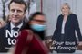 A woman passes by electoral campaign posters of French President and La Republique en Marche (LREM) party candidate for re-election Emmanuel Macron (L) and French far-right party Rassemblement National (RN) presidential candidate Marine Le Pen in Savenay, western France on April 19, 2022. - Emmanuel Macron won 27.85 percent of votes in the first round of France's presidential election, while far-right veteran Marine Le Pen scored 23.15 percent, according to final results from the interior ministry on April 18, 2022. (Photo by Loic VENANCE / AFP)<!-- NICAID(15072338) -->