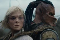 (L-R) Thia (Elle Fanning) and Dek (Dimitrius Schuster-Koloamatangi) in 20th Century Studios' PREDATOR: BADLANDS film. Photo courtesy of 20th Century Studios. Â© 2025 20th Century Studios. All Rights Reserved.Terras Selvagens (2025), filme de Dan Trachtenberg<!-- NICAID(16162460) -->