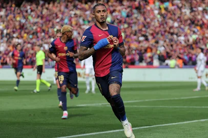 Barcelona's Brazilian forward #11 Raphinha (L) celebrates scoring their fourth goal during the Spanish league football match between FC Barcelona and Real Madrid CF at Estadi Olimpic Lluis Companys in Barcelona, on May 11, 2025. (Photo by LLUIS GENE / AFP)<!-- NICAID(16034899) -->