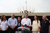 Brazil's right-wing Senator and presidential candidate for the Liberal Party (PL) Flavio Bolsonaro (C) speaks to the media alongside his wife Fernanda Bolsonaro (2-R) following a mass marking the celebration of Brazil's patron saint, Our Lady of Aparecida, at the Metropolitan Cathedral of Brasilia in Brasilia, Brazil, on October 12, 2026. (Photo by Sergio LIMA / AFP)<!-- NICAID(16385639) -->