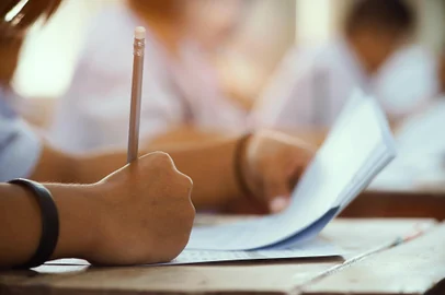 Closeup to hand of student  holding pencil and taking exam in classroom with stress for education test.Fonte: 188431708<!-- NICAID(15307143) -->