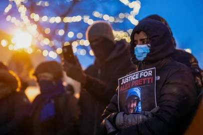 People mourn at a makeshift memorial in the area where 37-year-old Alex Pretti was shot dead by federal immigration agents earlier in the day in Minneapolis, Minnesota, on January 24, 2026. Federal immigration agents shot dead a man in Minneapolis on Saturday, in the second fatal shooting of a civilian during the Trump administration's unprecedented operation in the city, sparking fresh protests and outrage from state officials. The death came less than three weeks after US citizen Renee Good was shot and killed by an ICE officer. (Photo by ROBERTO SCHMIDT / AFP)<!-- NICAID(16211020) -->