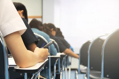 Hands university student holding pen writing /calculator doing examination / study or quiz, test from teacher or in large lecture room, students in uniform attending exam classroom educational school.Fonte: 312397076<!-- NICAID(14793488) -->