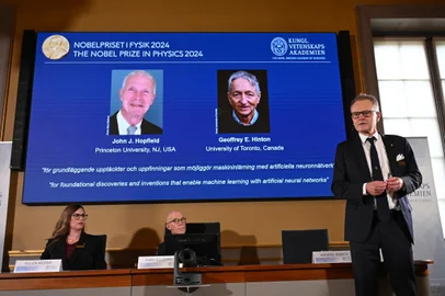 A screen shows the laureates of the 2024 Nobel Prize in Physics, US physicist John J Hopfield and Canadian-British computer scientist and cognitive psychologist Geoffrey E Hinton as member of the Nobel Committee for Physics Anders Irbaeck (R) delivers a speech following the announcement at the Royal Swedish Academy of Sciences in Stockholm, Sweden on October 8, 2024. American John Hopfield and British-Canadian Geoffrey Hinton won the Nobel Prize in Physics on October 8, 2024 for pioneering work in the development of artificial intelligence. (Photo by Jonathan NACKSTRAND / AFP)Editoria: HUMLocal: StockholmIndexador: JONATHAN NACKSTRANDSecao: physicsFonte: AFPFotógrafo: STR<!-- NICAID(15885770) -->