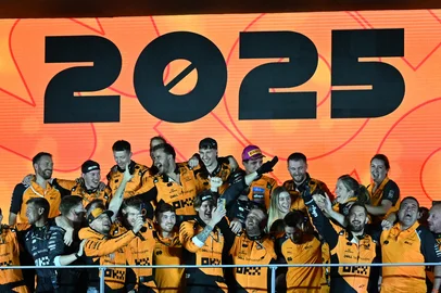 McLaren team's members celebrate their Formula One constructors' championship on the podium after the Formula One Singapore Grand Prix night race at the Marina Bay Street Circuit in Singapore on October 5, 2025. (Photo by ROSLAN RAHMAN / AFP)<!-- NICAID(16139869) -->
