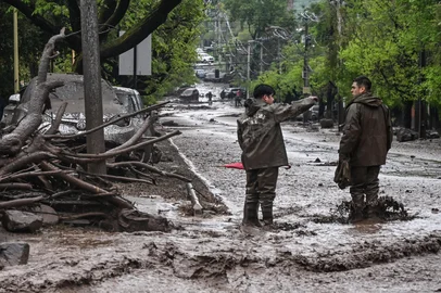 Carabineros stand in a mud-covered street following a mudslide in the Las Condes district of Santiago on October 8, 2026. (Photo by RODRIGO ARANGUA / AFP)<!-- NICAID(16383746) -->